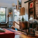 Interior of cozy studio with bed and couch decorated with vintage furniture and vinyl records
